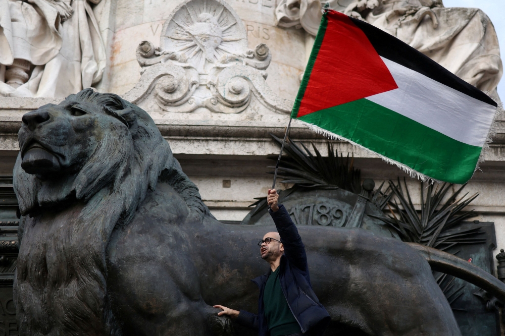 A protester holds a Palestinian flag during a protest to condemn the Israeli forces’ interception of the vessels of the Global Sumud Flotilla aiming to reach Gaza and break Israel’s naval blockade and for the release of the crews, and to protest against Israel’s operations in the Gaza Strip, amid the ongoing Israel-Hamas conflict, at the Place de la Republique in Paris, France, October 2, 2025. — Reuters pic