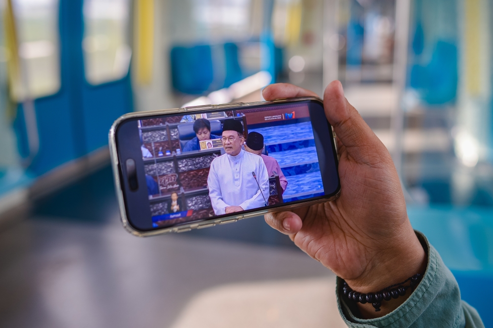 Private sector worker Amirul Dinie, 30, watches the live broadcast of the 2026 Budget presentation by Prime Minister Datuk Seri Anwar Ibrahim in Kuala Lumpur, October 10, 2025. — Bernama pic 