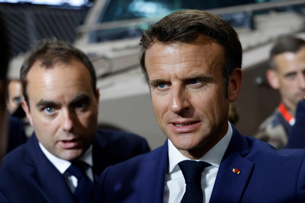 Emmanuel Macron (right) and Sebastien Lecornu visit the booth of the French Ministry of Armed Forces at the Eurosatory trade fair in Villepinte, north of Paris, on June 13, 2022. — AFP pic