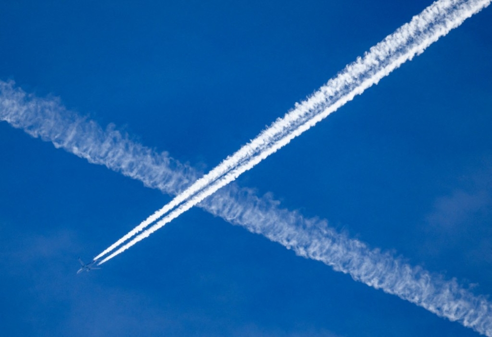 An airplane leaves contrails in the blue sky above Saxony, Dresden March 19, 2024. — Robert Michael/dpa/dpa Picture-Alliance pic via AFP