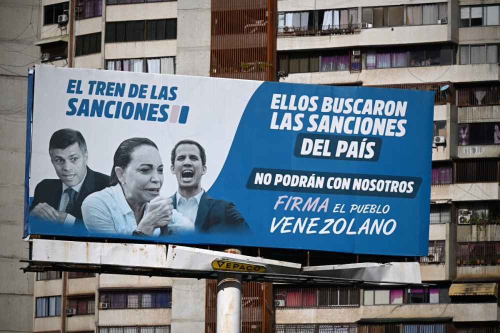 A billboard accusing opposition leaders (from left) Leopoldo Lopez, Maria Corina Machado and Juan Guaido, for the US sanctions imposed on the country, is seen in Caracas on October 10, 2025, after Machado was awarded the Nobel Peace Prize. — AFP pic