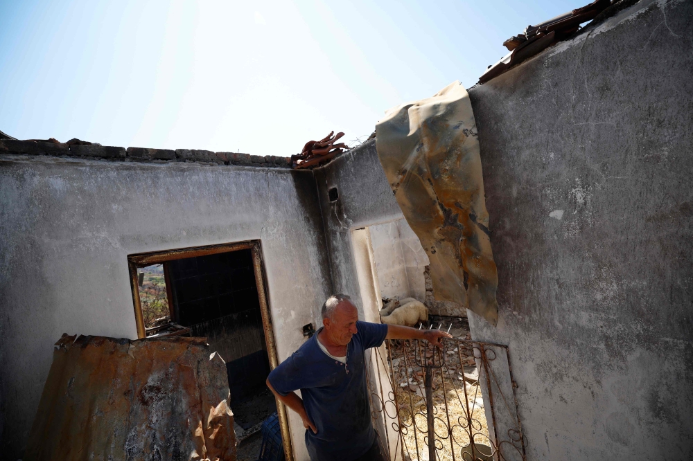 Kujtim Palloshi stands in his house destroyed by a wildfire, in Skenderbegas, near Gramsh September 16, 2025. — AFP pic