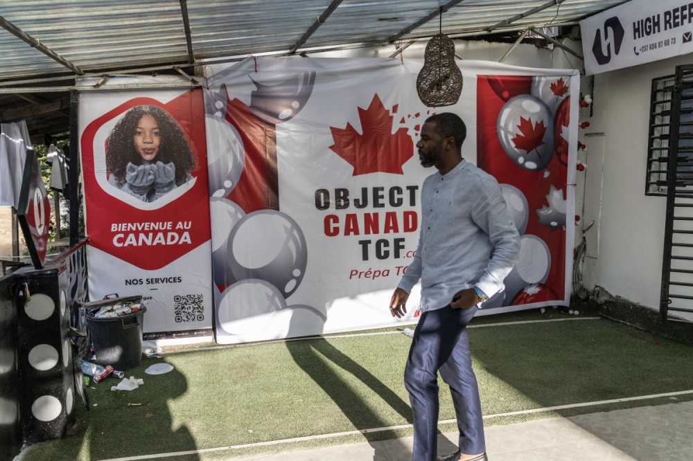 A man walks past a billboard advertising the preparation to the French Comprehension Test (TCF) finalised to expatriation to Canada, at a Objectif Canada centre in Douala October 6, 2025. Cameroon, where four out of ten residents live below the national poverty line of €452 per year, according to a 2024 World Bank report, has been ruled for 43 years by the world’s oldest head of state, and candidate for re-election in the October 12 presidential election, Paul Biya. — AFP pic 