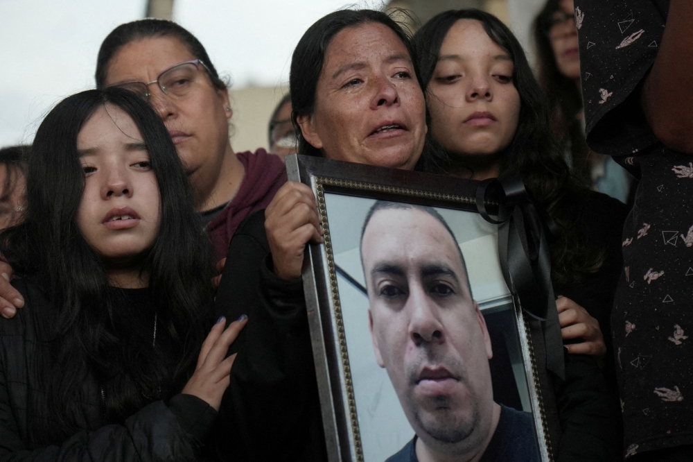 Graciela holds a framed photo of her brother, Silverio Villegas Gonzalez, 38, a man from Michoacan who was fatally shot by a US Immigration and Customs Enforcement (ICE) agent in Franklin Park, Illinois, shortly after dropping off his two children at a nearby elementary school and daycare, during his burial at a cemetery in Irimbo, Mexico, September 26, 2025. — Reuters pic