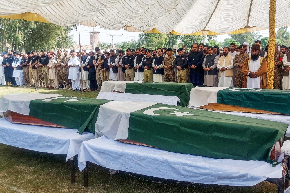 Security personnel and mourners gather around the coffins of police officers killed in a suicide bombing at a training school, during a funeral ceremony in Dera Ismail Khan, Khyber Pakhtunkhwa province, on October 11, 2025. The Pakistani Taliban claimed responsibility for coordinated attacks across several northwestern districts that left 20 security personnel and three civilians dead. — AFP pic