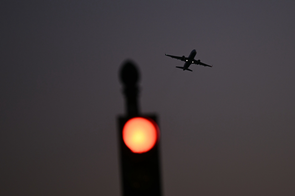 An airplane takes off from Reagan National Airport on the ninth day of the federal government shutdown on October 9, 2025 in Arlington, Virginia. Civil servants who are required keep working because they are considered essential — like air traffic controllers — do so without pay.  — AFP pic 