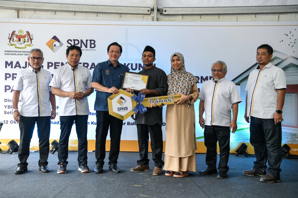 Political Secretary to the Prime Minister, Chan Ming Kai hands over mock-up house keys to some of the recipients of Rumah Mesra Rakyat at the Kedah Rumah Mesra Rakyat key handover ceremony in Kampung Badlishah October 12, 2025. — Bernama pic
