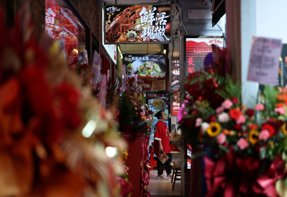 Flowers and well-wishes are displayed outside Xiahuang Crayfish, a newly-opened Chinese restaurant, at Liang Seah Street in central Singapore October 10, 2025. — Reuters pic