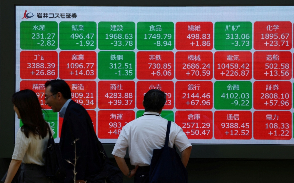 A man looks at an electronic board displaying sector performances related to Nikkei index outside a brokerage in Tokyo May 13, 2025. — Reuters pic 