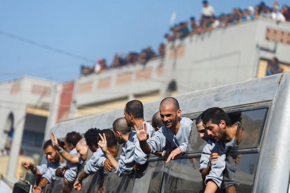Freed Palestinian prisoners gesture from a bus after they were released by Israel as part of a hostages-prisoners swap and a ceasefire deal between Hamas and Israel, in Khan Younis in the southern Gaza Strip, October 13, 2025. — Reuters pic 