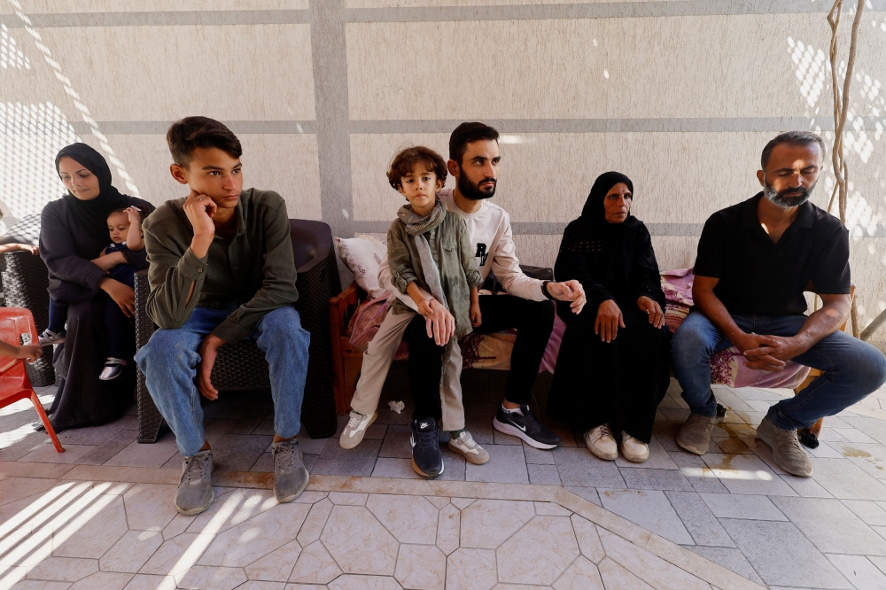 Freed Palestinian detainee Shadi Abu Sido sits with his relatives at their home in Nuseirat, central Gaza Strip, on October 14, 2025, after his release from Israeli detention as part of a ceasefire deal between Hamas and Israel. — Reuters pic