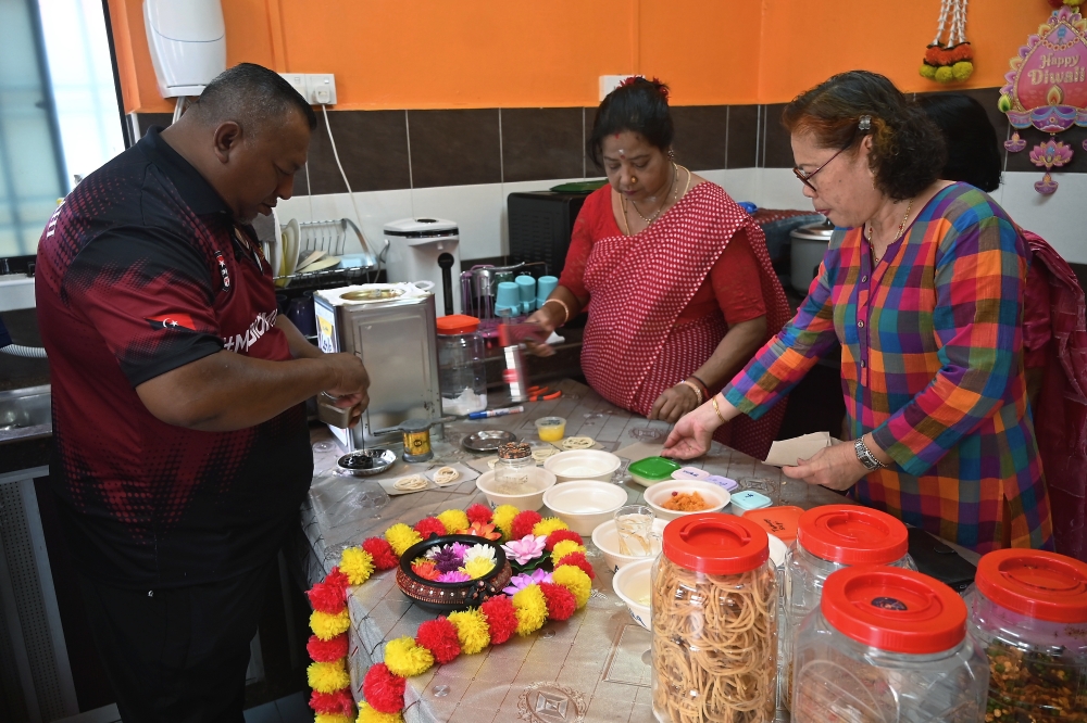 S. Artiletchumy, 60, (centre) with her family members preparing traditional food to celebrate Deepavali, namely murukku, which uses the family's ancestral recipes. — Bernama pic