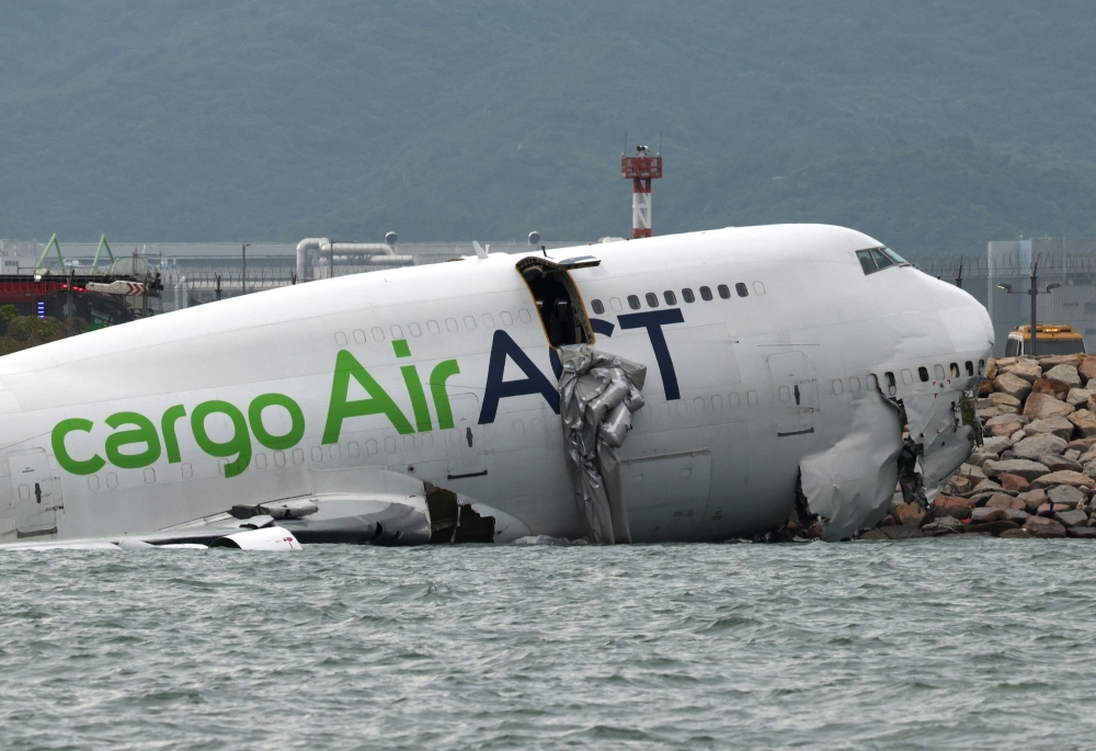 A cargo plane lies partially in the sea after veering off the runway during landing at Hong Kong International Airport in Hong Kong October 20, 2025. — Reuters pic 