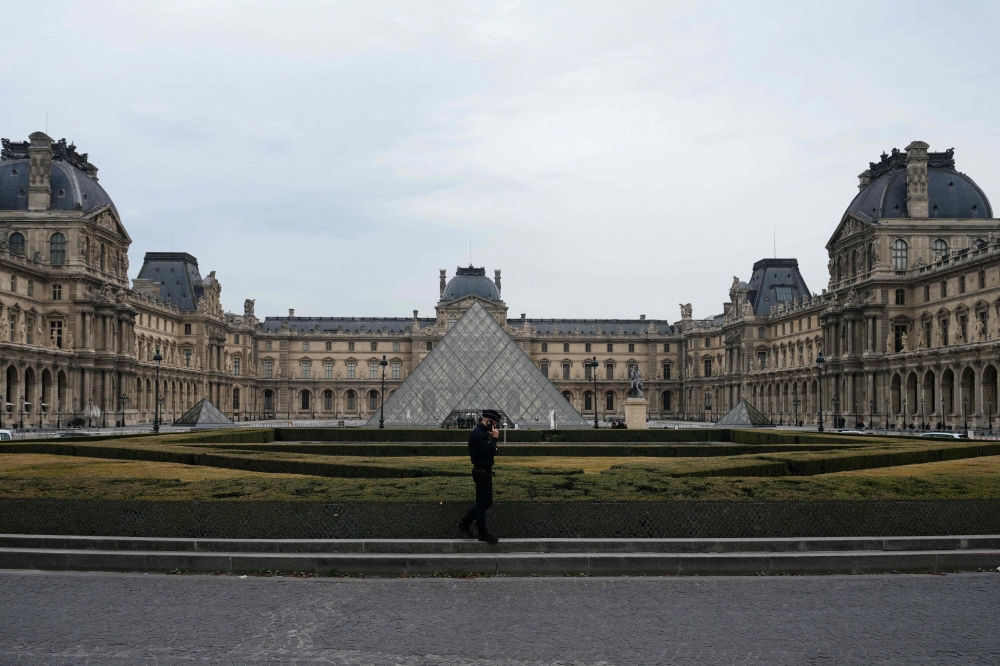 A French police officer walks in front of the Louvre Museum after robbery, in Paris on October 19, 2025. — AFP pic 