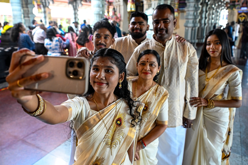 Pushalini James takes a selfie with her family members at the Sri Balathandayuthapani Temple in Seremban, October 20, 2025. — Bernama pic 
