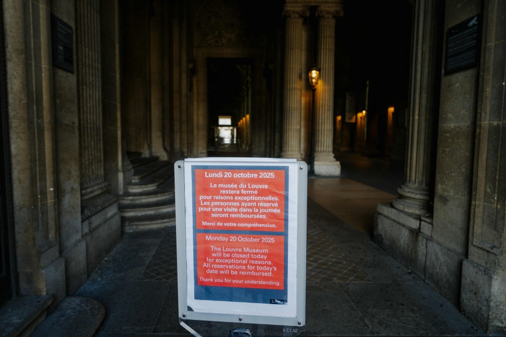 A close sign is seen at the Louvre pyramid courtyard for a second day after thieves stole priceless jewels from the museum in Paris a day earlier, in Paris on October 20, 2025. — AFP pic
