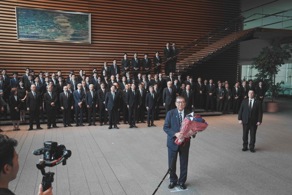 Japan’s outgoing Prime Minister Shigeru Ishiba (centre) speaks to the media as he leaves the prime minister’s office on his final day as the Japanese leader in Tokyo on October 21, 2025. — AFP pic