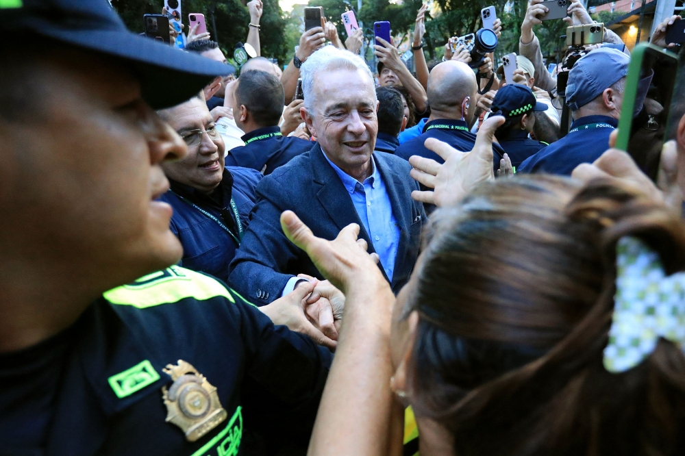Former Colombian President Alvaro Uribe Velez (centre) greets a supporter after being released from house arrest in Sabaneta, Antioquia department, Colombia on August 20, 2025. — AFP pic 