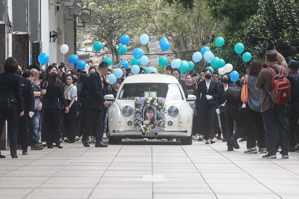 Family and friends escort the hearse carrying the late Yap Shing Xuen as it departs for her cremation in Shah Alam, at Nirvana Kuala Lumpur yesterday. — Picture by Sayuti Zainudin.