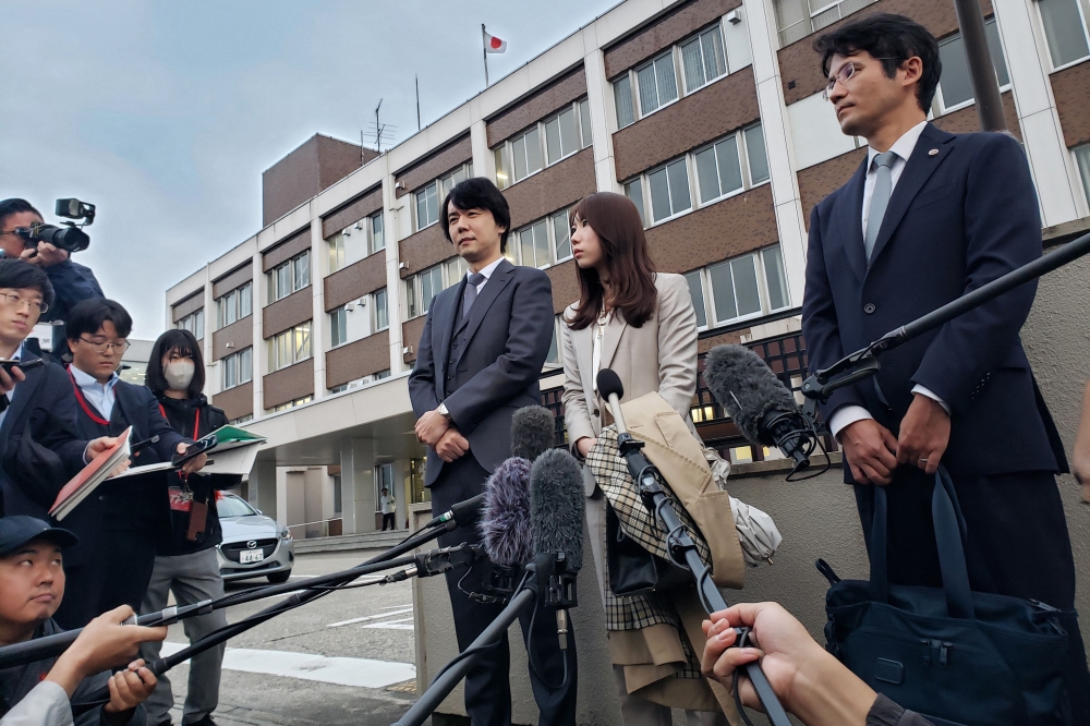 Riho Fukuyama (centre) and her husband Yoshiki speak to the media outside the Toyama District Court on October 21, 2025. after her father was jailed eight years for raping her when she was in high school. — AFP pic