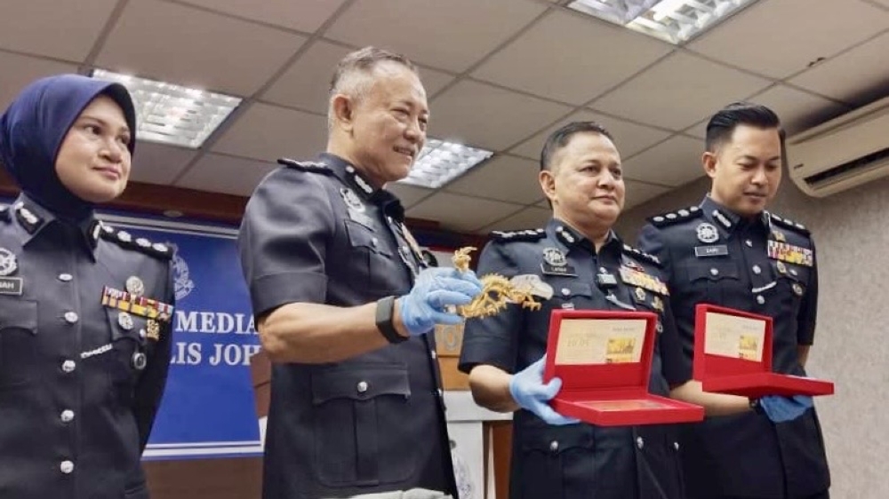 Johor deputy police chief Abdul Latiff Mehat (third from left) with some of the recovered items seized from the suspects at the Johor police contingent headquarters in Johor Bahru today Oct 22, 2025. —  Picture by Ben Tan