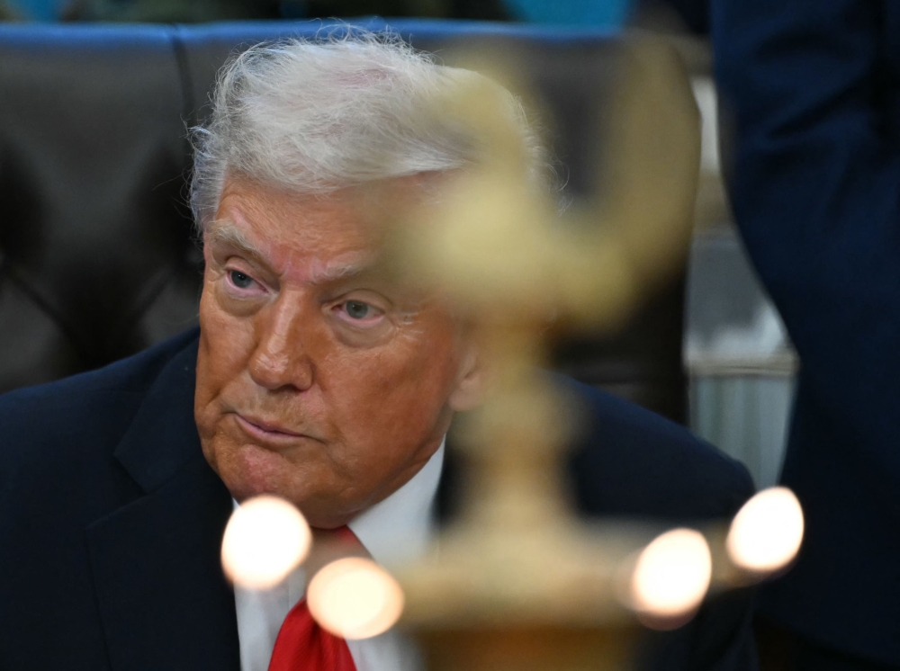 US President Donald Trump looks on as candles are lit during a Diwali celebration with American Indian leaders in the Oval Office of the White House in Washington, DC October 21, 2025. — AFP pic