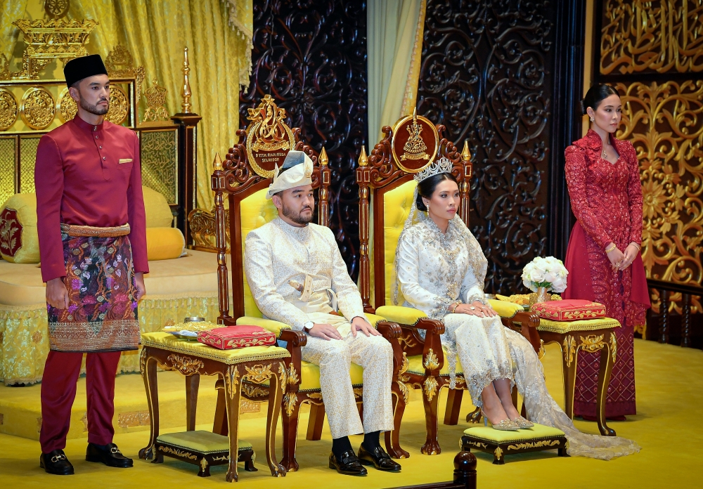 The bride and groom sit on the dais looking resplendent in their cream royal attire. — Bernama pic 
