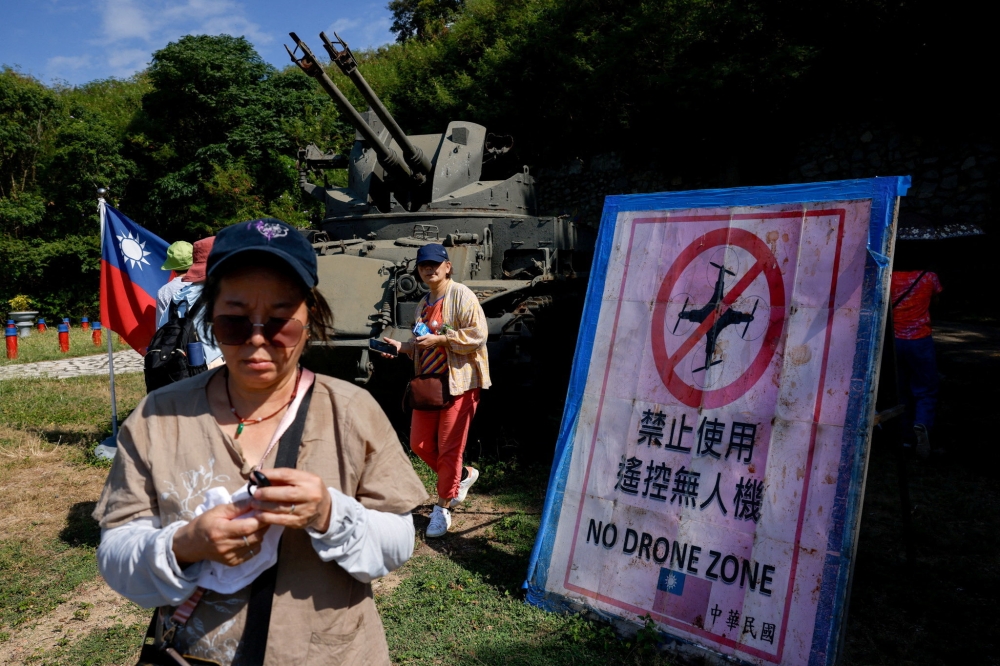Tourists walk past a ‘No Drone Zone’ sign next to a self-propelled anti-aircraft gun on display facing China's Xiamen, on Dadan Island, Kinmen, Taiwan, October 18, 2025. — Reuters pic
