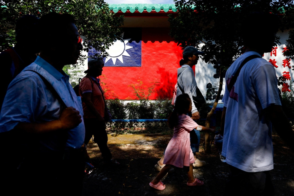 Tourists walk past a wall painted with a Taiwan flag, on Dadan Island, Kinmen, Taiwan, October 18, 2025. — Reuters pic
