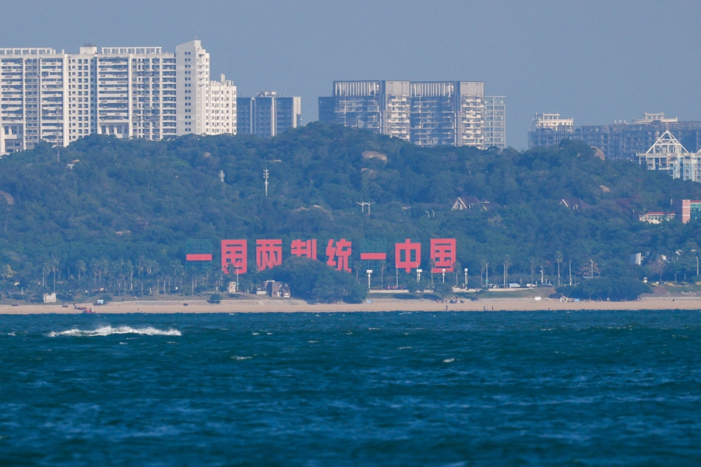 A hillside slogan reading ‘One country, two systems; reunifying China’ is displayed in China's Xiamen, as seen from Dadan Island, in Kinmen, Taiwan, October 18, 2025. — Reuters pic