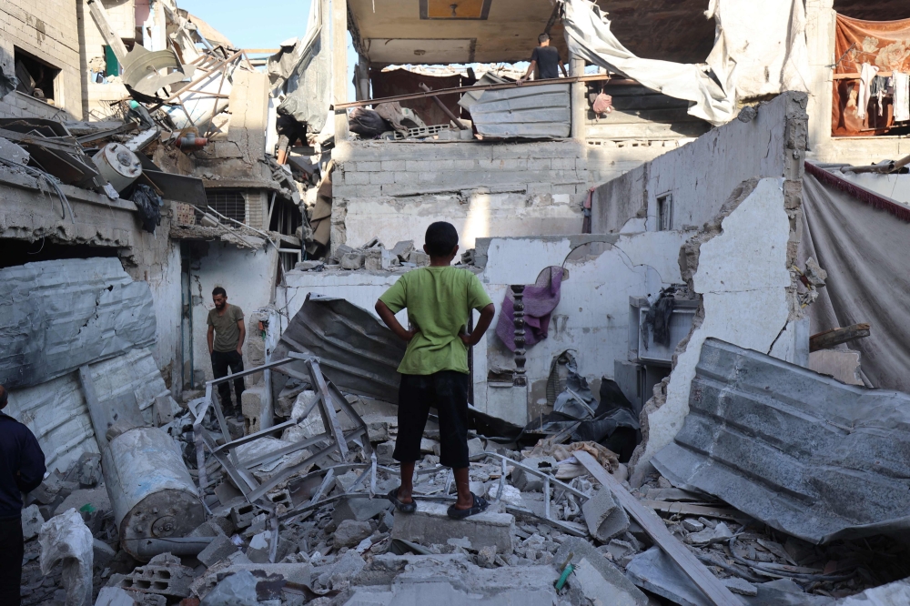 Palestinians inspect the damage around their homes after an Israeli strike targeted the Bureij refugee camp in the central Gaza Strip on October 20, 2025. — AFP pic