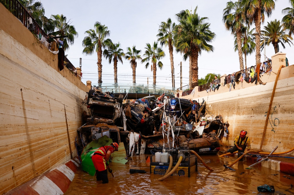 Firefighters pump floodwater out of a tunnel where vehicles are piled up, after heavy rains in Alfafar, in Valencia, November 1, 2024. — Reuters pic
