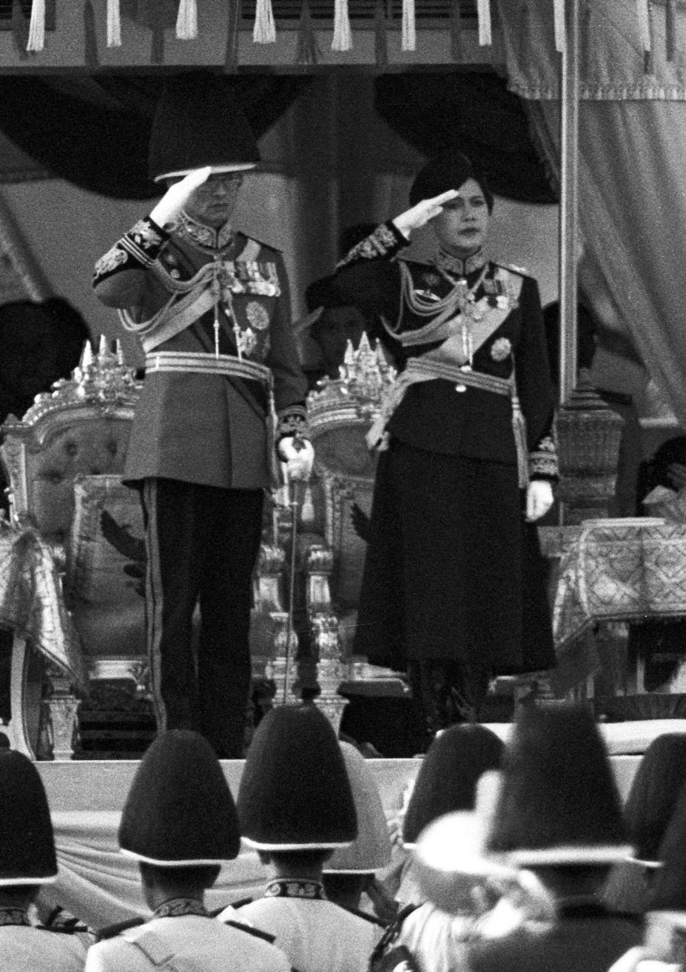 Thai King Bhumibol Adulyadej and Queen Sirikit salute as they review a guard of honour unit during a military parade in Bangkok December 3, 1989. — Reuters pic