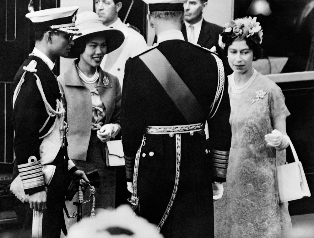 This undated photo taken in July 1960 shows Thailand's King Bhumibol Adulyadej (left), and Queen Sirikit (2nd left) being welcomed by Queen Elizabeth II and Philip, Duke of Edinburgh, upon their arrival in London. — Central Press/AFP pic