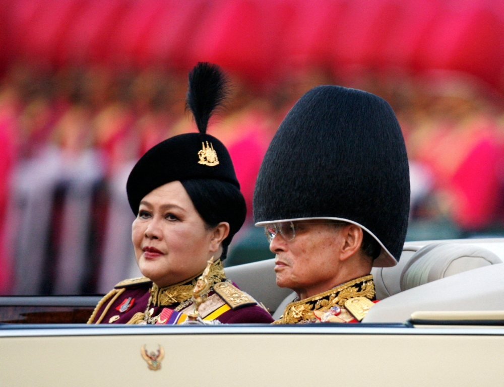 Thailand’s King Bhumibol Adulyadej reviews a parade with Thailand’s Queen Mother Sirikit to mark his 79th birthday in Bangkok, December 2, 2006. — Reuters pic