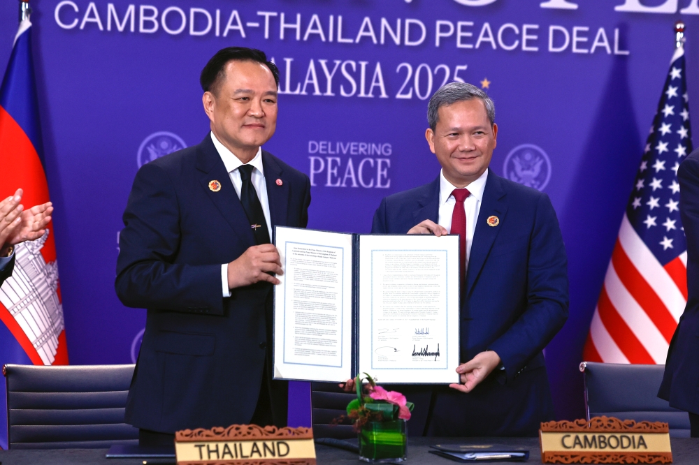 Cambodian Prime Minister Hun Manet and Thai Prime Minister Anutin Charnvirakul display the signed joint declaration of the peace deal, dubbed the ‘KL Peace Accord,’ at the 47th Asean Summit and Related Summits at the Kuala Lumpur Convention Centre October 26, 2025. — Bernama pic