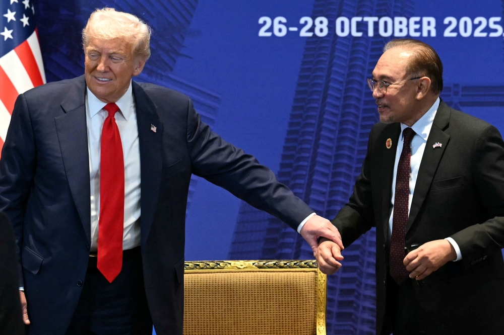 US President Donald Trump gestures to Malaysia’s Prime Minister Datuk Seri Anwar Ibrahim during a meeting on the sidelines of the 47th Association of Southeast Asian Nations (Asean) Summit in Kuala Lumpur October 26, 2025. — Mohd Rasfan/Pool/Reuters pic
