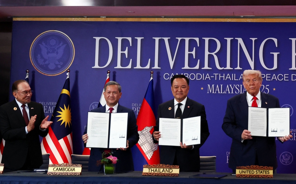 Malaysia’s Prime Minister Datuk Seri Anwar Ibrahim applauds as Thailand’s Prime Minister Anutin Charnvirakul, Cambodia’s Prime Minister Hun Manet and US President Donald Trump hold up documents, during the signing of a ceasefire deal between Cambodia and Thailand on the sidelines of the 47th Association of South-east Asian Nations (Asean) summit in Kuala Lumpur October 26, 2025. — Reuters pic