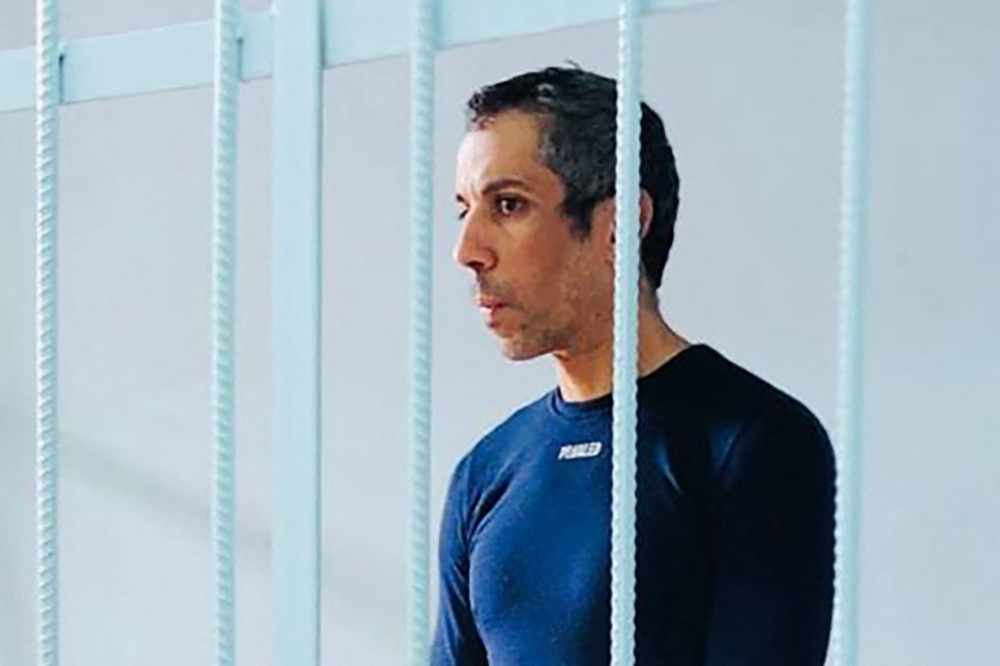 In this handout picture taken on October 23, 2025 and released by the united press service of the Primorsky Krai region courts, French cyclist Sofiane Sehili, who was arrested on suspicion of crossing the Russian border illegally while attempting to complete his world record attempt for cycling across Eurasia, stands inside a defendants' cage during a court hearing in the far eastern settlement of Pogranichnyy. — Primorsky Krai via AFP