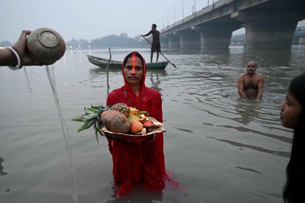 Hindu devotees gather to offer prayers to the Sun god on the occasion of 'Chhath Puja' festival, along the banks of river Yamuna in New Delhi on October 27, 2025. — AFP pic