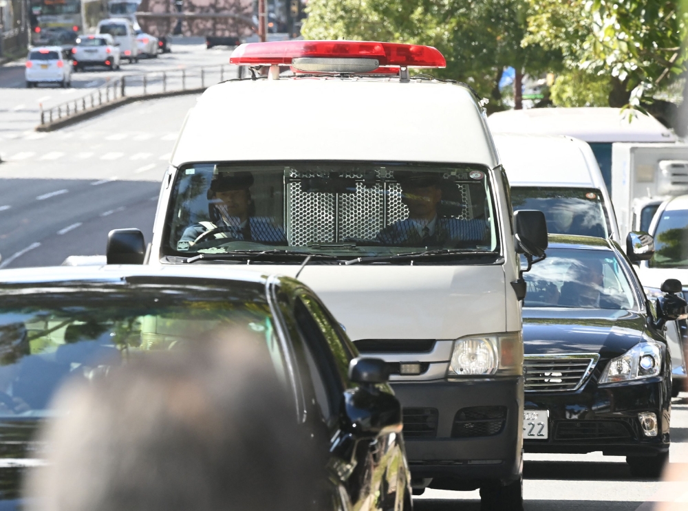 A car believed to be carrying defendant Tetsuya Yamagami (centre) is seen en route to the Nara District Court for his first trial in Nara, Nara Prefecture October 28, 2025. — Jiji Press/AFP pic 