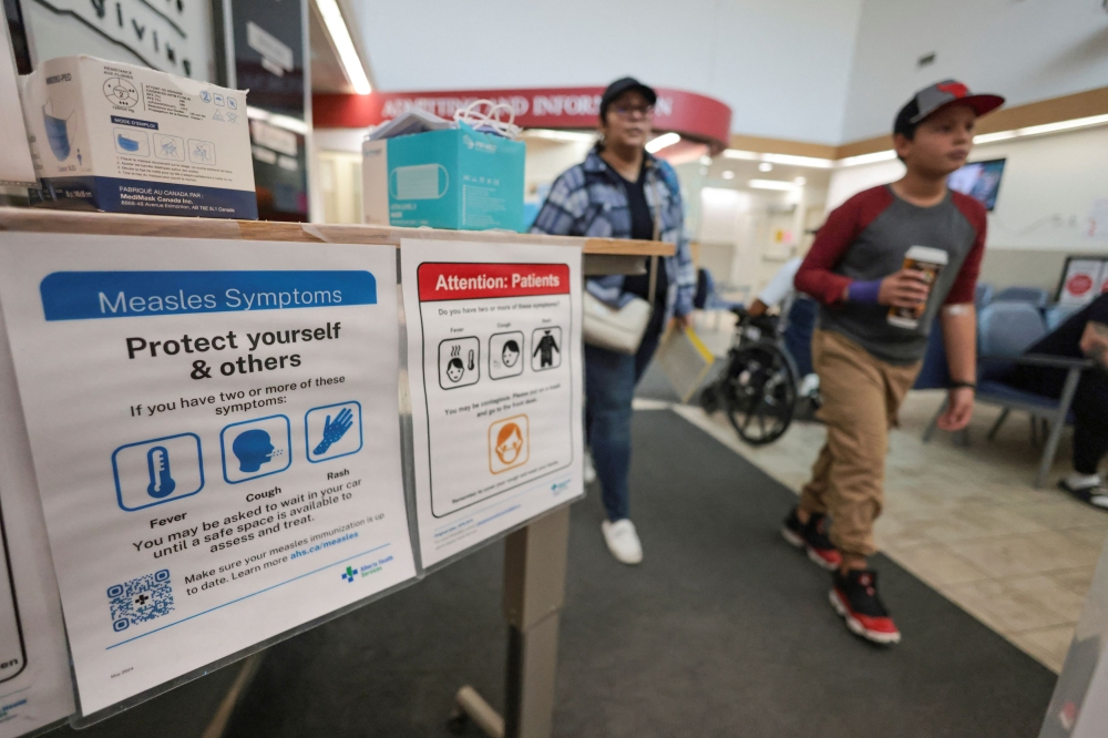 People pass near healthy awareness posters related to the measles outbreak during a public health outreach, at the Taber Health Centre, in the largely Mennonite community of Taber, Alberta October 27, 2025. — Reuters pic