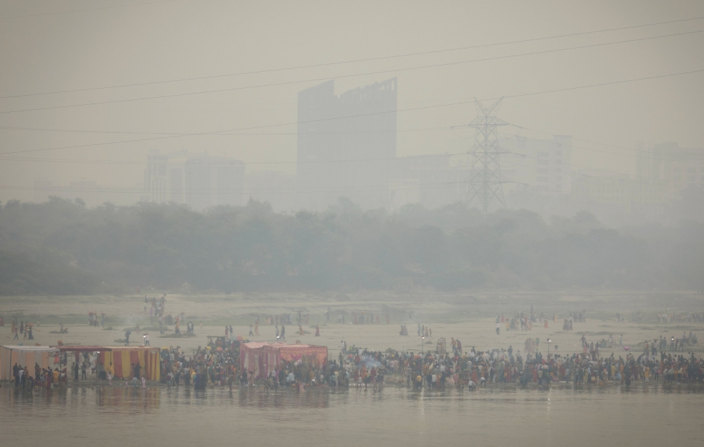 Hindu devotees worship the Sun god on the banks of Yamuna river during the Hindu religious festival of Chhath Puja on a smoggy morning in Noida on the outskirts of New Delhi October 28, 2025. — Reuters pic