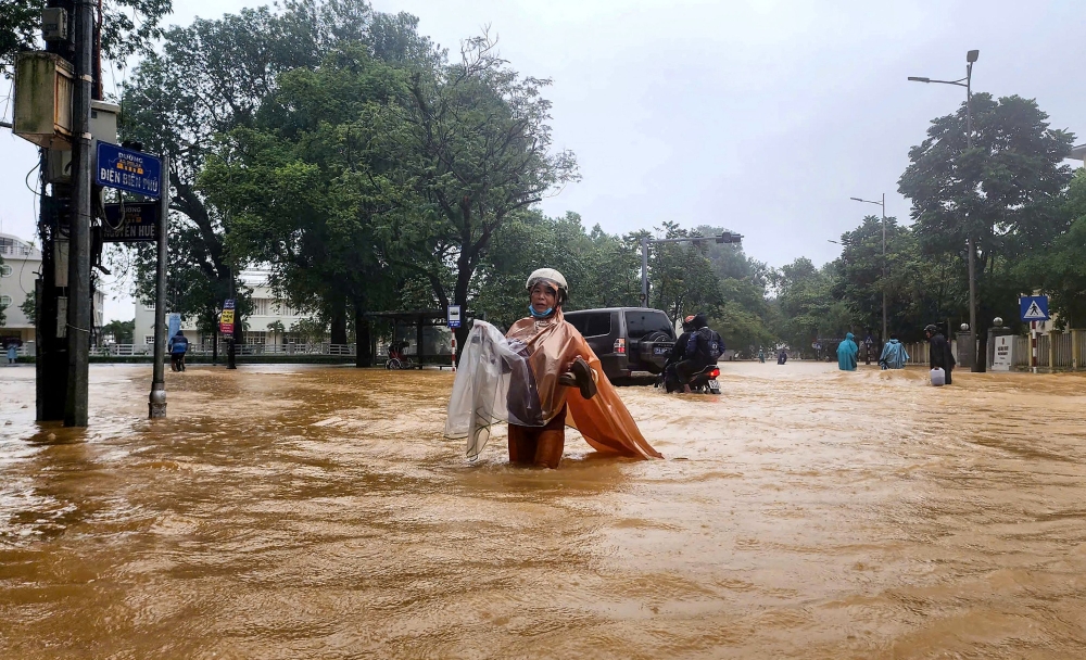 A woman wearing a raincoat wades through a flooded street in Hue on October 28, 2025. The central Vietnamese city of Hue recorded more than a metre of rainfall in a 24-hour period, smashing a national record set over two decades ago, the environment ministry said. — AFP pic 