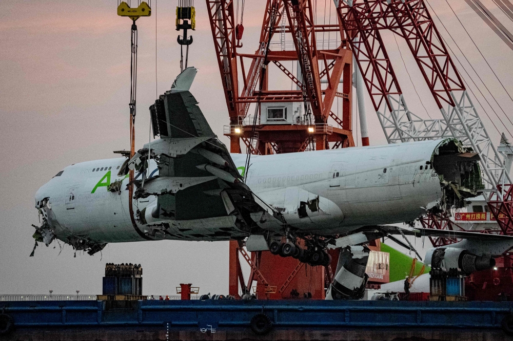 The main fuselage section of an ACT Airlines Boeing 747-400 cargo aircraft, wet leased by Emirates SkyCargo, is hoisted out of the water in Hong Kong on October 26, 2025, after it veered off an airport runway on October 20 during landing, hitting a security patrol car and then skidding into the sea, leaving two men in the vehicle dead. — AFP pic 