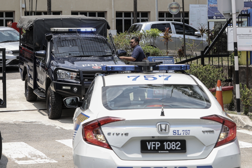 Police vehicles are seen at a Bandar Utama school were a student was fatally stabbed, on Oct 14, 2025. — Bernama pic