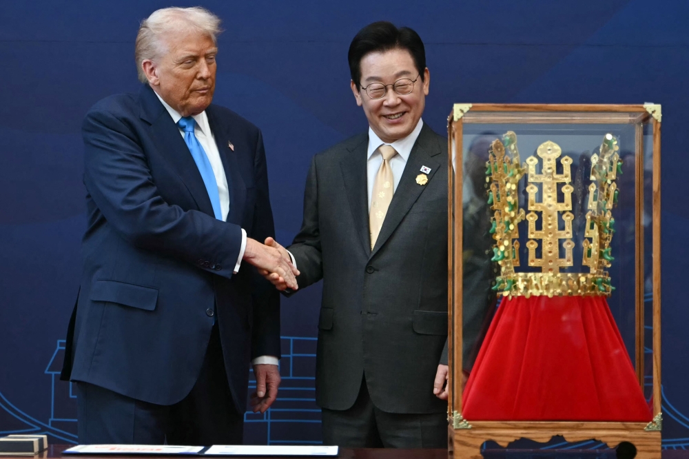 US President Donald Trump shakes hands with South Korean President Lee Jae Myung during a high honour presentation ceremony, where Trump was presented with a replica of a crown worn by the kings of Silla, at the Gyeongju National Museum in Gyeongju on October 29, 2025. — AFP pic 