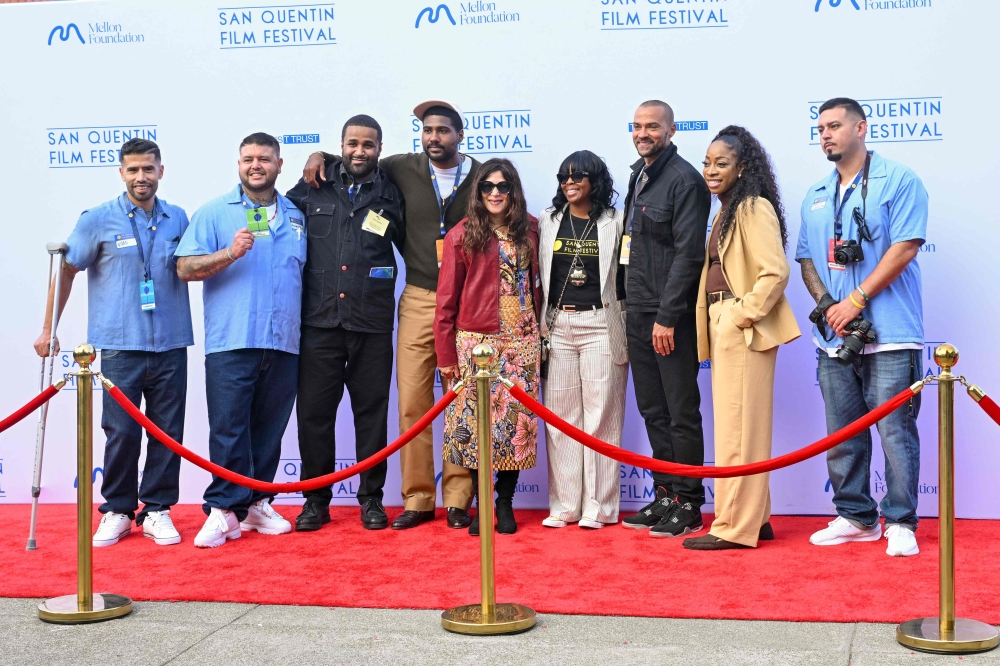 Founder of the San Quentin Film Festival Cori Thomas (centre) and TV star Jesse Williams (third from right) pose with guests and inmates on the red carpet of the film festival at San Quentin Rehabilitation Center in San Quentin, California, on October 24, 2025. — AFP pic