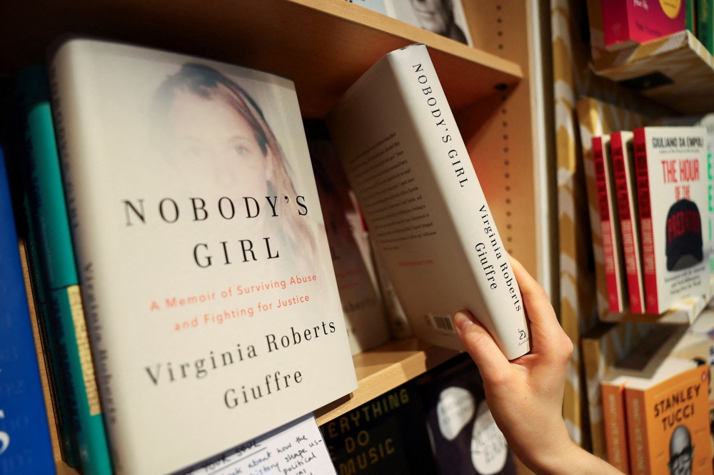 A shop assistant at Foyles bookshop in London, Britain, arranges copies of 