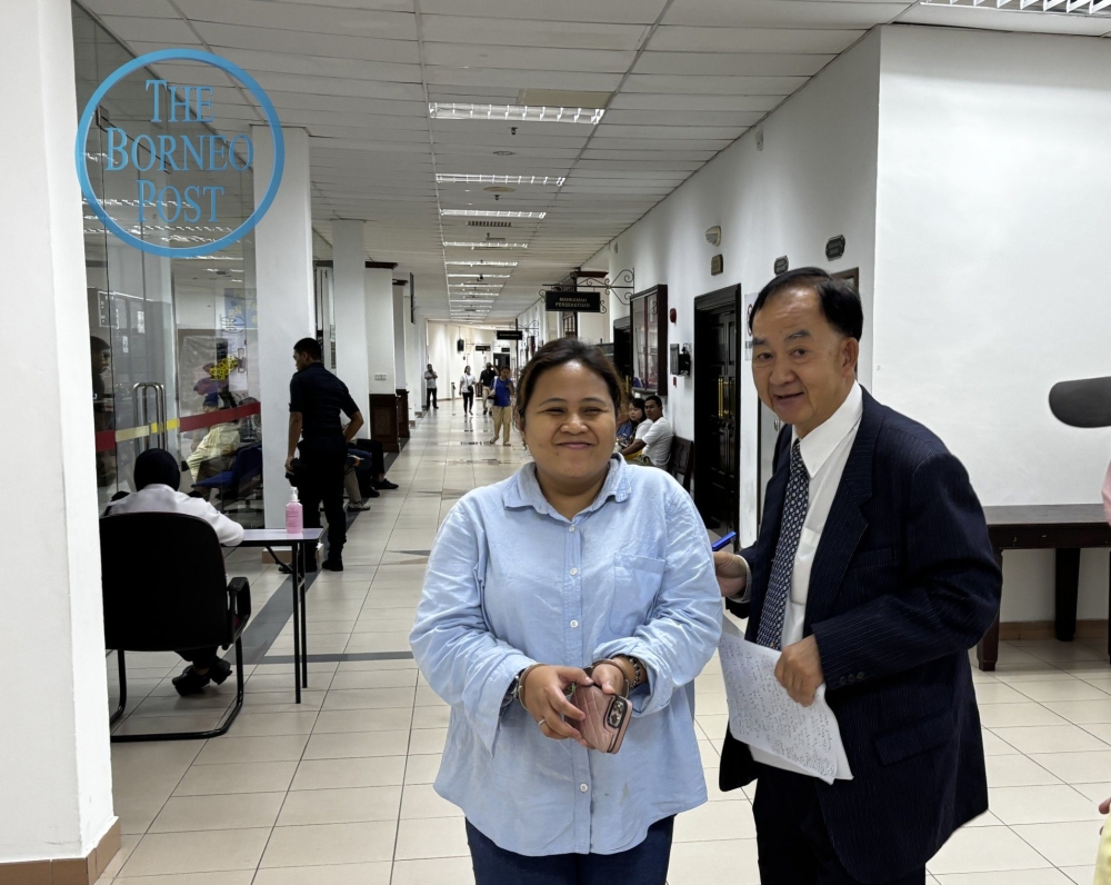 Anis and Lim are seen in the lobby of the Kuching Court Complex. — The Borneo Post pic